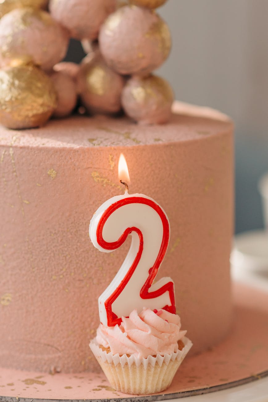 lighted candle on a pink cupcake